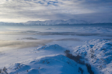 Aerial view of misty Kuray steppe in winter. Altai Republic, Siberia, Russia..