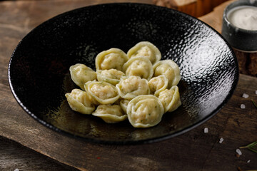 Appetizing traditional Russian dumplings, handmade. Still life on a wooden board. Close-up.