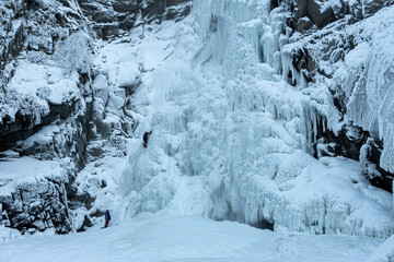 Ice climbers on frozen Kurkure waterfall (icefall). Chulyshman river valley, Altai Republic, Russia.