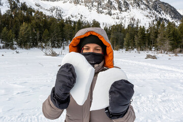 Fototapeta na wymiar Young woman holds a broken snow heart. Altai Republic, Russia.