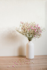 Gypsophila. Spring is coming concept. Flowers and candies. Modern ceramic vase with gypsophila. White wall background. Scandinavian interior. 