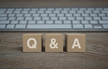 Q and A word on block cubes on wooden table with computer keyboard, Frequently asked questions,...