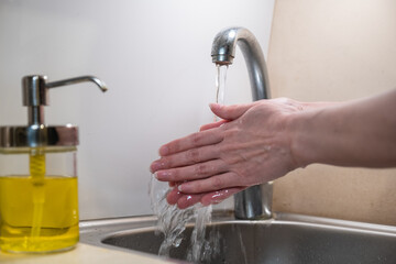 Washing hands with soap. woman washing hands with soap over the sink in the bathroom, close-up. Covid-19. Coronavirus: Cleaning hands.