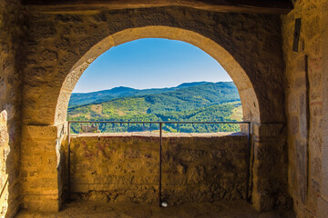 A partially blocked arch overlooking the nearby landscape in the historic medieval village of Santa...