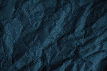 Black blue green crumpled rough paper background. Wrinkled texture of colored packaging. Grunge background with copy space for design.