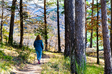 Fototapeta premium Blonde woman with curly hair, walking through the forests of the Ribes de Freser Valley in the Ripolles region, Girona, Catalonia