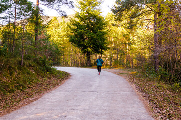 Fototapeta premium Blonde woman with curly hair, walking through the forests of the Ribes de Freser Valley in the Ripolles region, Girona, Catalonia