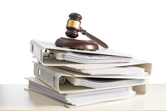 Stack Of Files With Gavel On Table Against White Background