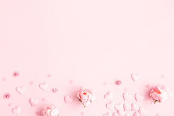 Valentine's Day background. Frame made of pink flowers, hearts on pastel pink background....