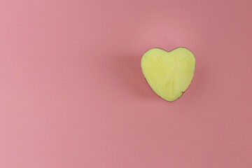 Half heart shaped potatoes on a pink background. Concept of farming, harvesting, vegetarianism