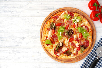Pizza with ham and salad on wooden background