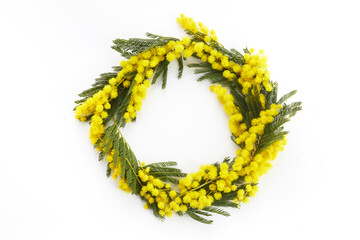 Wreath made of mimosa flowers on white background. Flat lay, top view, copy space.