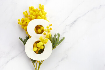 Greeting for International Women's Day on March 8th. Branches of mimosa and number eight. - obrazy, fototapety, plakaty