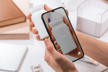 Man using a phone app to identify a bottle of pills