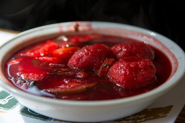 Traditional hot red beet Kubbe soup, a famous middle eastern dumplings soup dish, served in a bowl. Jerusalem, Israel. 