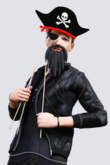 海賊船の船長風のフォトプロップスを頭と顔につけて写真を撮る黒いレザーのジャケットを着た男の子