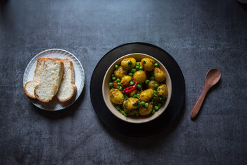 Aloo dum or steamed potatoes in gravy in a bowl. A popular food item across north and eastern India. Close up, selective focus.