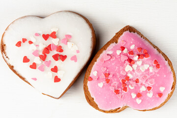one pink and one white heart-shaped gingerbreads on white background