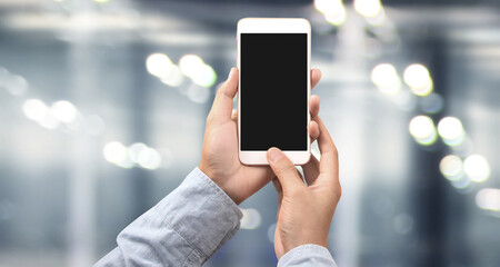 Hand holding smartphone device touching screen