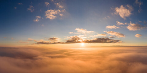 view from an airplane on a beautiful saturated sunrise above the clouds