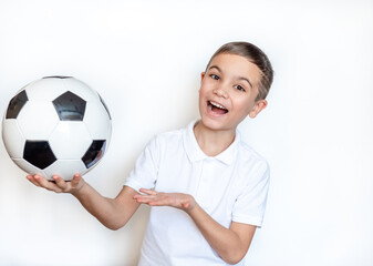 Portrait of an emotional child Boy holding a soccer ball in his hand. Boy in a white T-shirt on a white background. Looking at camera. Place for text. 