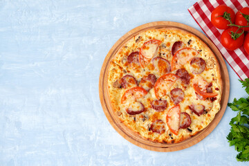 Delicious pizza with sausages on gray background
