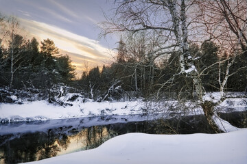 Winter landscape the river in the forest at sunset. Winter sunset rural river landscape.