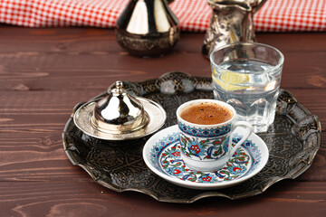 Obraz na płótnie Canvas Cup of coffee in oriental style on metal tray