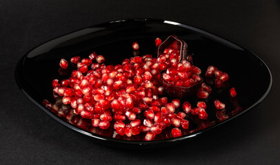 juicy red pomegranate seeds on a black background