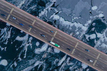 A beautiful winter view from a drone to the winter bridge with tarnosmotorm. Ice covered river