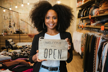 Portrait of the owner of the clothing store holding the sign with the words 