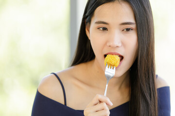 A beautiful young cute black long hair Asian woman try to test a food