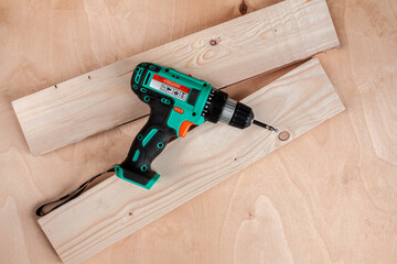 a black and green bolt cutter on two wood boards on wooden background