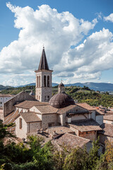 Fototapeta na wymiar A church with a mountain in the background in Spoleto Italy