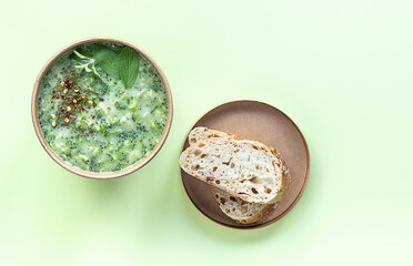 Fresh broccoli cream soup served fresh bread and spices in craft container. Vegetarian lunch to go.