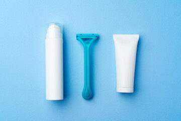 Shaving cream and disposable shaver on blue background