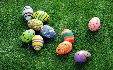 .Colorful painting easter eggs lay on fake green grass field