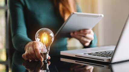 business woman using smartphone, tablet and holding light bulb, with idea with innovation and creativity.