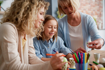 Close up of women decorating Easter eggs at home together