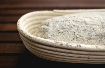 bread dough in fermentation basket on wooden table