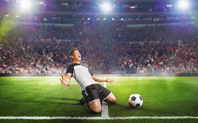 Ball on the green field in soccer stadium. Professional Soccer Player Does Knee Slide Celebrates...