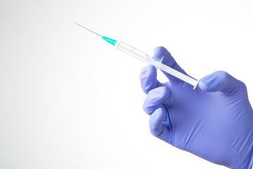 hand with blue glove holding a syringe isolated on white background