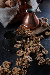 Peeled walnuts on a dark background. Coffee in a copper turk. Kernel of a walnut. Natural product. Vertical photo.