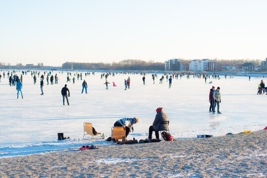 people enjoy ice skating. in zeewolde near Tulpeiland. profitable conditions. frozen lake. on a sunny day. flevoland the netherlands 11 Feb 2021