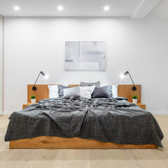 Big wooden bed in white bedroom