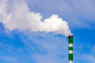 One Industrial smoke pipe from chimney on blue cloudy sky.