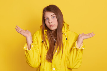 Clueless unaware woman with long hair, spreads palms in doubt, expresses uncertainty, has sad...