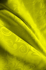 folds of yellow fabric close up. color trend of 2021