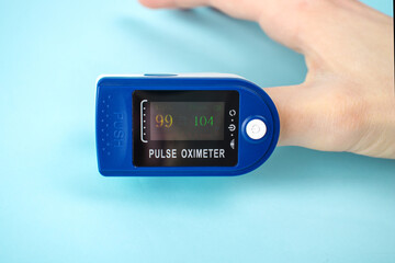 Pulse oximeter to measure pulse rate and oxygen levels isolated on blue background. Medical...