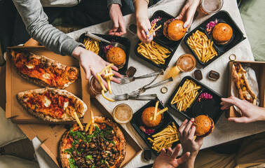 Lockdown fast food dinner from delivery service, getting together. Flat-lay of friends having...